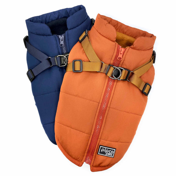 Load image into Gallery viewer, Flat laid orange Pipco puffer coat on top of navy puffer coat showing harness side
